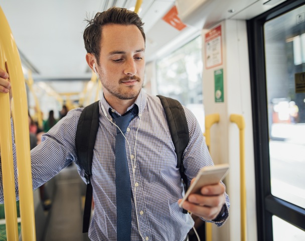 Man on the metro looking at his phone